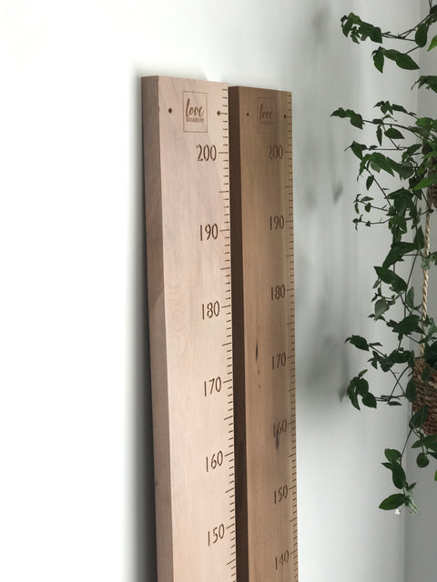 Whitewashed and natural rimu height chart rulers side by side