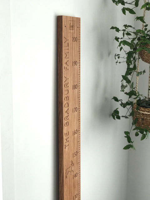 Personalised family name and modern animals carved into recycled rimu height chart